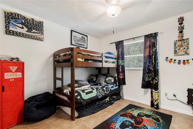 tiled bedroom featuring ceiling fan and a textured ceiling