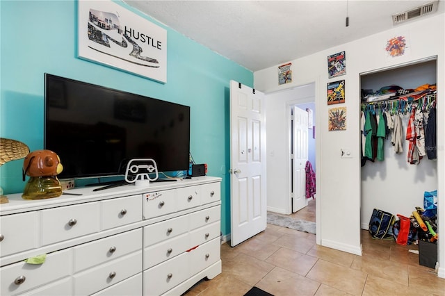 bedroom with a closet and light tile patterned floors