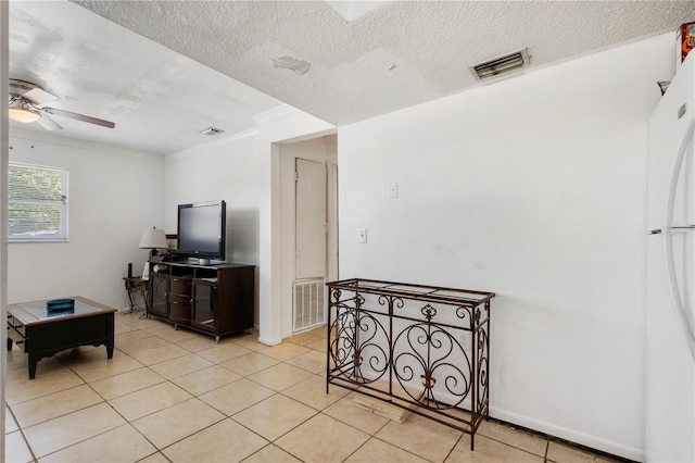 tiled living room with a textured ceiling, ceiling fan, and crown molding