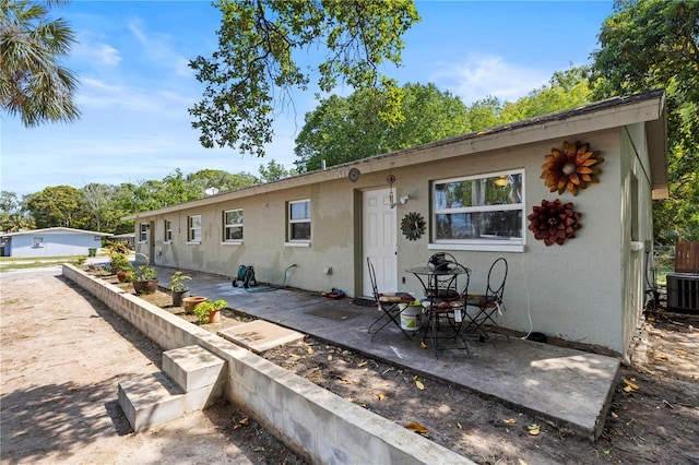 view of front facade with a patio and central AC unit