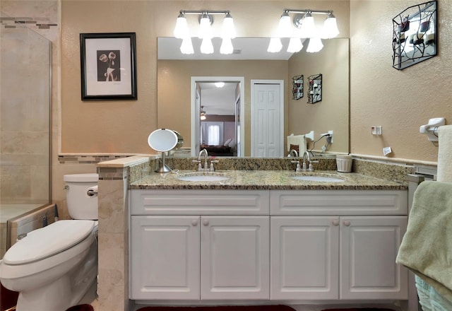 bathroom with vanity, toilet, and tiled shower