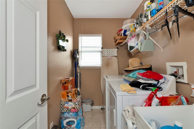 clothes washing area featuring light tile patterned floors and washing machine and clothes dryer