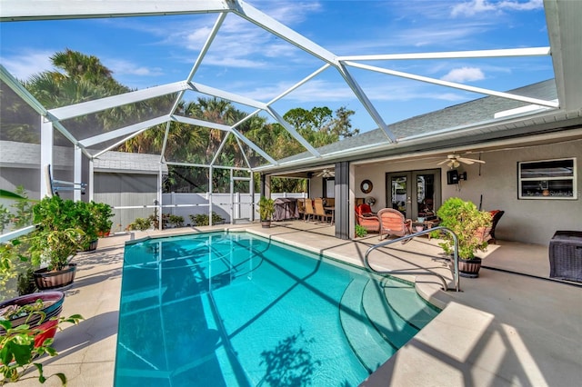 view of swimming pool with a patio, glass enclosure, ceiling fan, and french doors