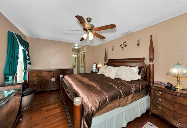 bedroom featuring dark hardwood / wood-style floors, ceiling fan, and ensuite bath