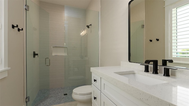 bathroom featuring tile patterned flooring, vanity, toilet, and a shower with door