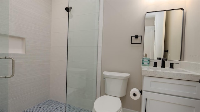 bathroom featuring vanity, toilet, and a shower with door