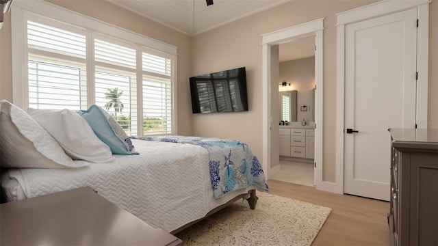 bedroom with connected bathroom, crown molding, and light hardwood / wood-style floors