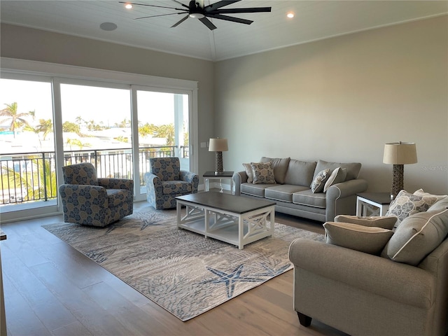 living room with wood-type flooring, a wealth of natural light, and ceiling fan