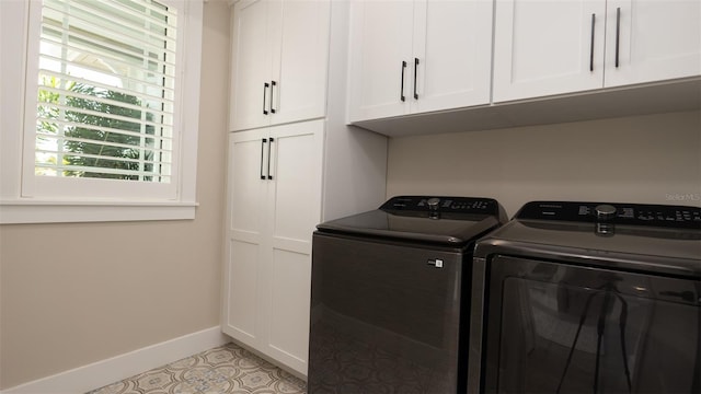 laundry room featuring cabinets, light tile patterned floors, and washing machine and clothes dryer