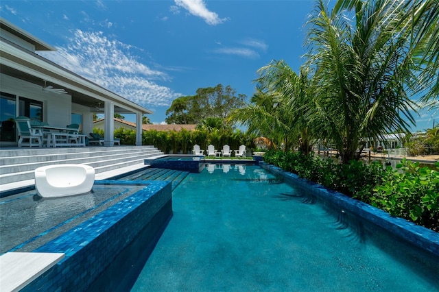 view of pool with ceiling fan and an in ground hot tub