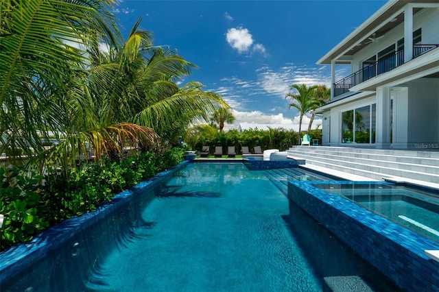 view of swimming pool with an in ground hot tub