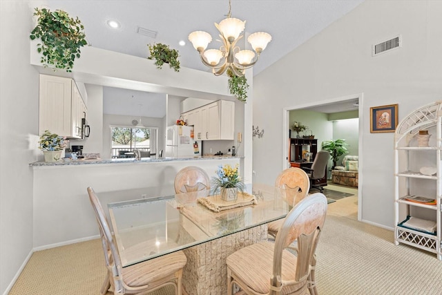 dining space featuring lofted ceiling, light carpet, and an inviting chandelier