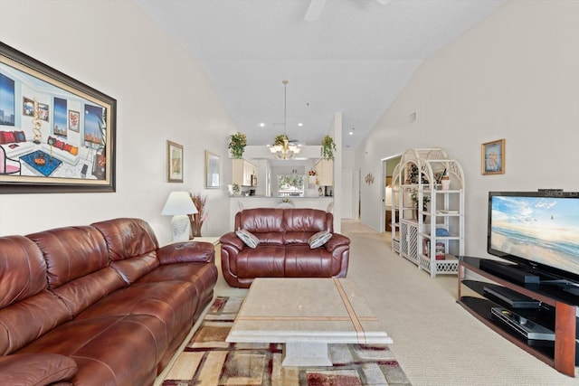 living room featuring light carpet, high vaulted ceiling, and an inviting chandelier