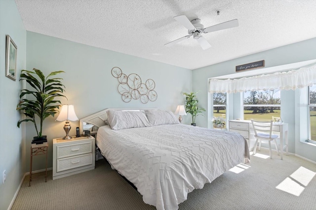 carpeted bedroom featuring a textured ceiling and ceiling fan