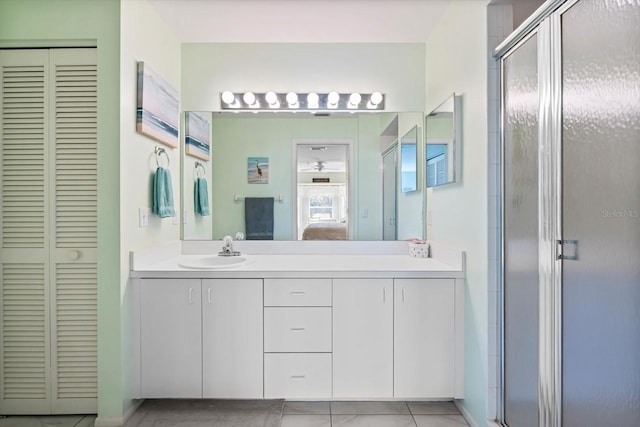 bathroom featuring tile patterned flooring, vanity, and a shower with shower door