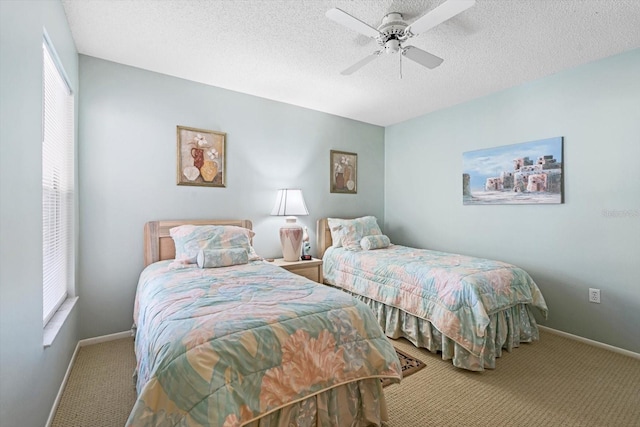 bedroom with ceiling fan, carpet floors, and a textured ceiling