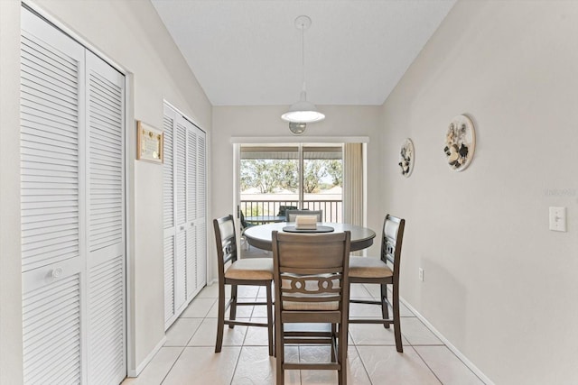 tiled dining area with vaulted ceiling