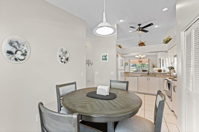 tiled dining room with ceiling fan with notable chandelier and sink