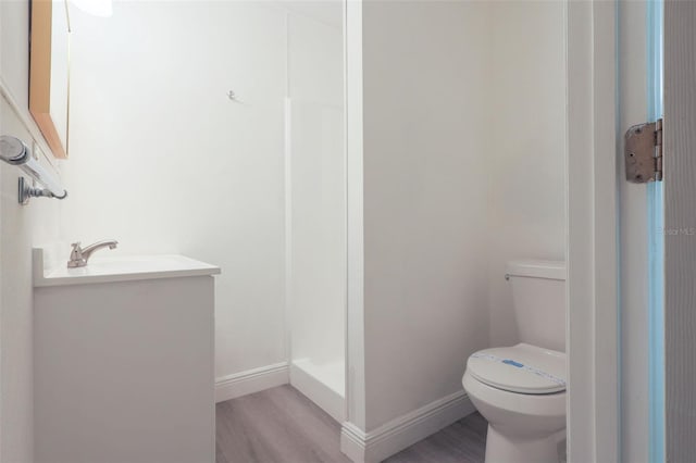 bathroom featuring toilet, vanity, and hardwood / wood-style flooring