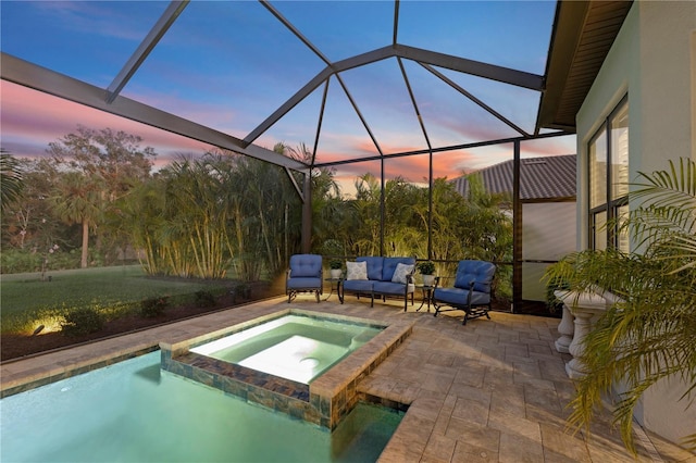 pool at dusk with outdoor lounge area, a patio, glass enclosure, and an in ground hot tub