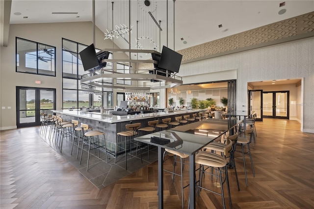 kitchen with parquet floors, high vaulted ceiling, and french doors