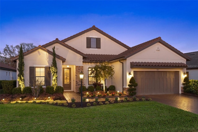 mediterranean / spanish-style house with a garage and a lawn