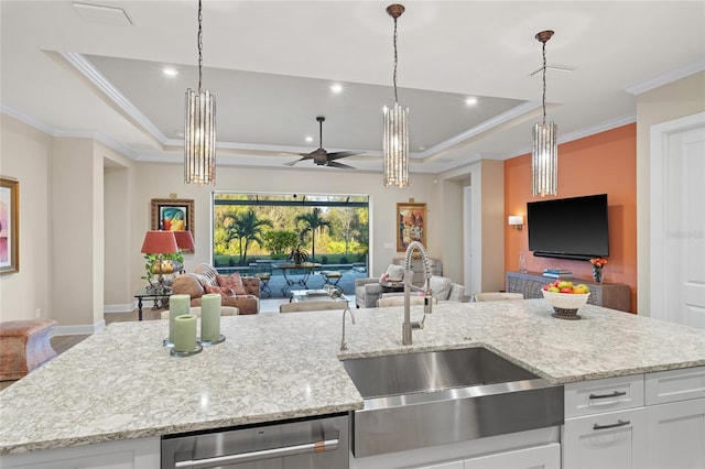 kitchen featuring sink, white cabinetry, stainless steel dishwasher, a raised ceiling, and an island with sink