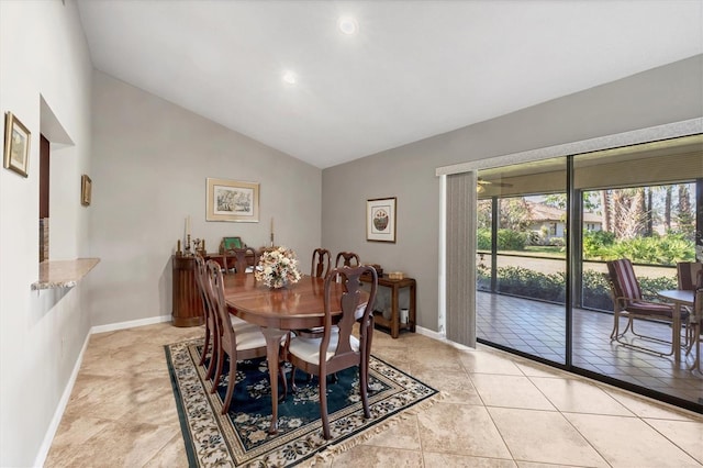 tiled dining room featuring lofted ceiling