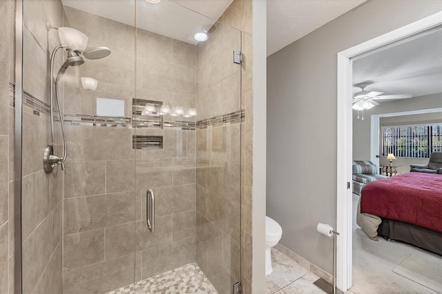 bathroom featuring tile patterned flooring, toilet, and a shower with shower door