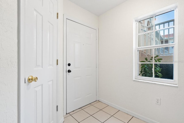 doorway to outside with light tile patterned floors