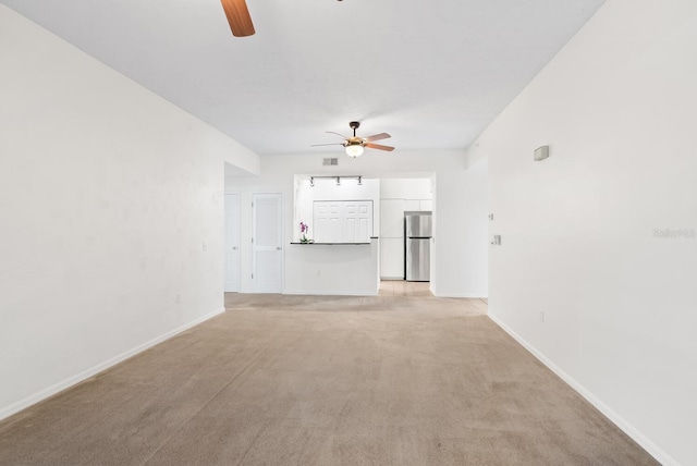 unfurnished living room featuring light colored carpet and ceiling fan