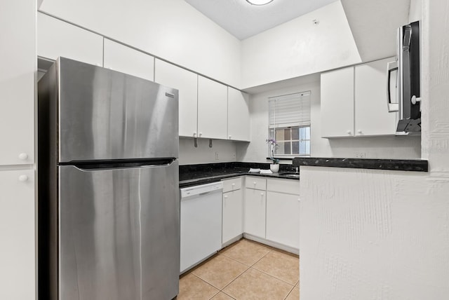 kitchen with white cabinets, stainless steel fridge, white dishwasher, and light tile patterned floors