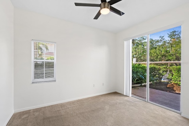 spare room with light carpet, ceiling fan, and a healthy amount of sunlight