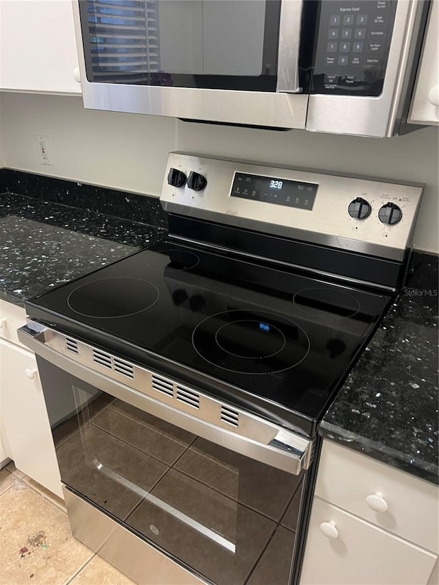 interior details featuring dark stone countertops, white cabinets, and appliances with stainless steel finishes