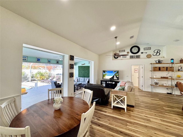 dining area featuring hardwood / wood-style flooring, vaulted ceiling, and ceiling fan