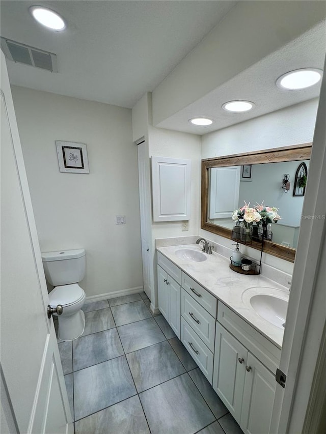 bathroom featuring tile patterned flooring, vanity, and toilet