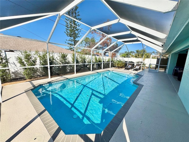 view of pool featuring glass enclosure and a patio