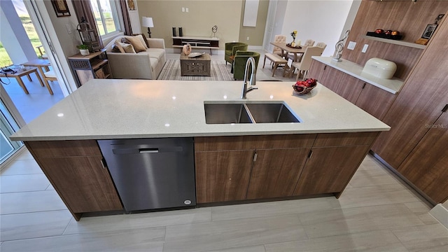 kitchen with light tile patterned floors, an island with sink, stainless steel dishwasher, and sink