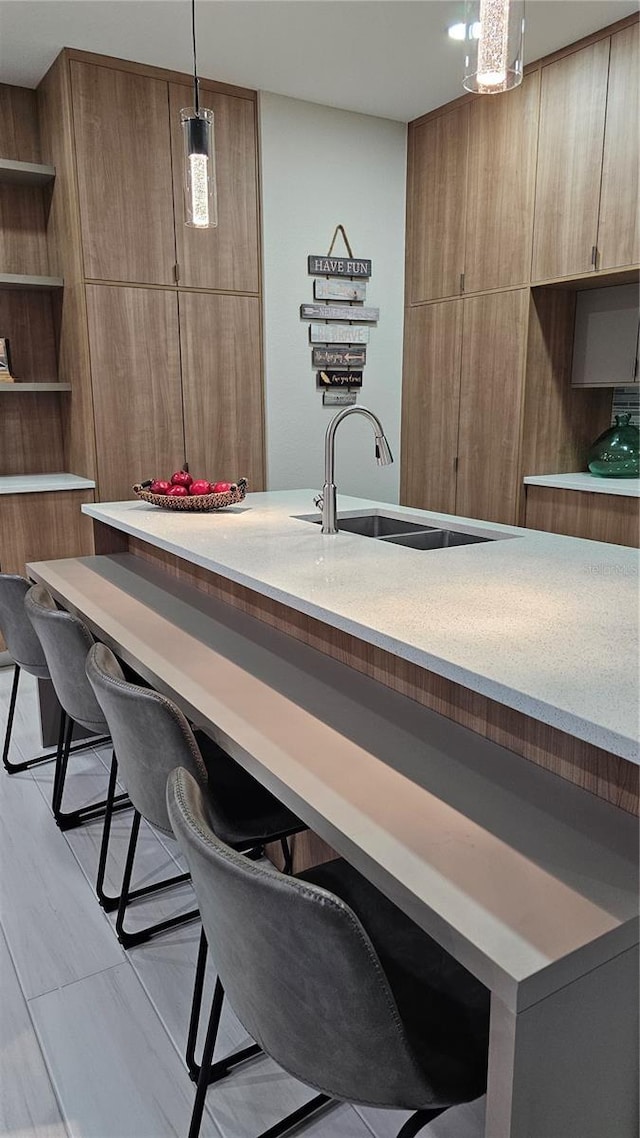 bar featuring light tile patterned floors, decorative light fixtures, and sink