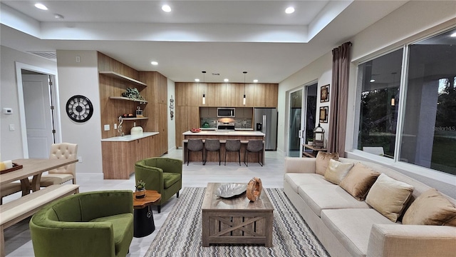 living area featuring recessed lighting and a tray ceiling