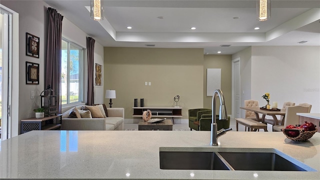 1859 Lamont St, North Port, FL 34288 - kitchen featuring a sink, a raised ceiling, recessed lighting, light stone counters, and open floor plan
