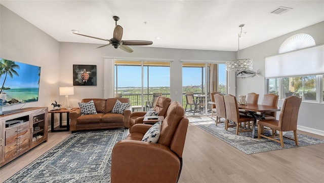 living room featuring light wood-type flooring, plenty of natural light, and ceiling fan