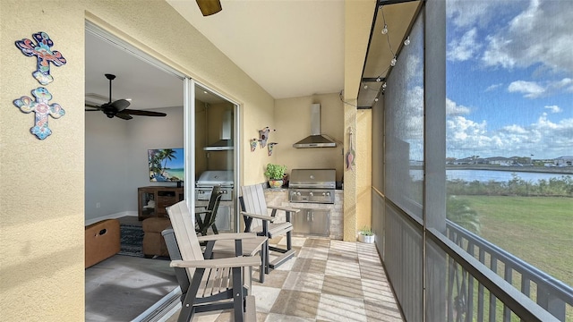 sunroom / solarium featuring ceiling fan and a water view