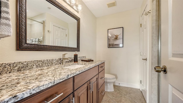 bathroom featuring tile patterned floors, vanity, a shower with shower door, and toilet