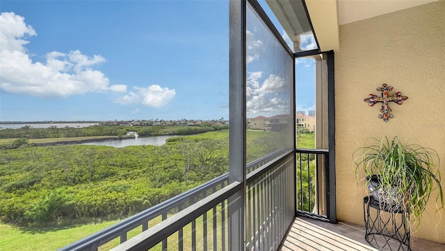 sunroom / solarium featuring a water view