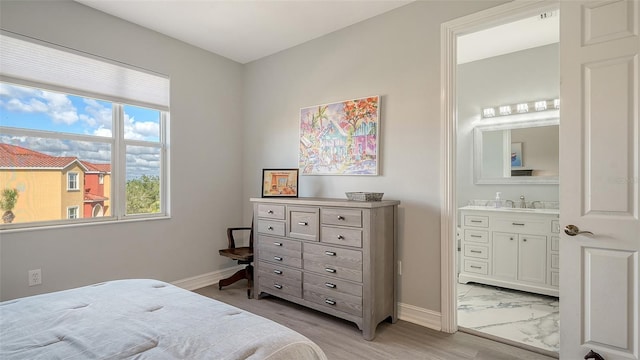 bedroom featuring ensuite bath and sink