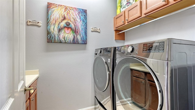 washroom featuring cabinets and independent washer and dryer