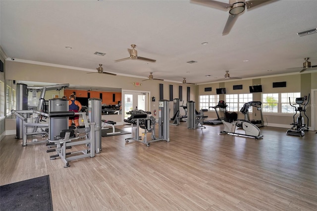 workout area with light wood-type flooring and crown molding