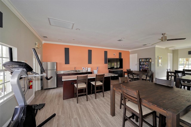 dining space featuring light hardwood / wood-style floors, plenty of natural light, crown molding, and ceiling fan