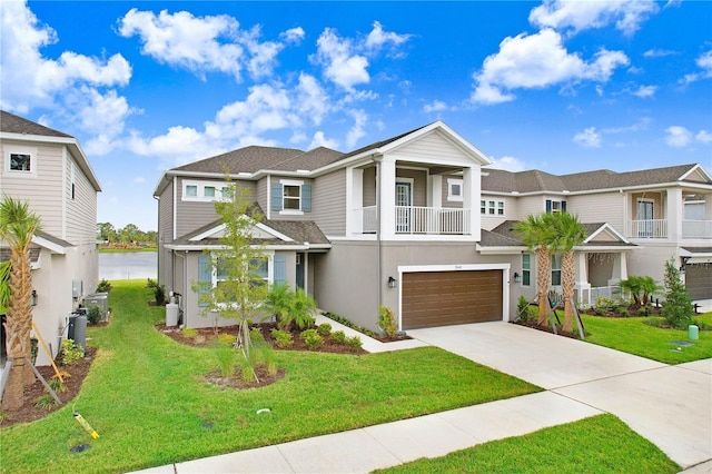 view of front of home with a front lawn, a balcony, a water view, and a garage